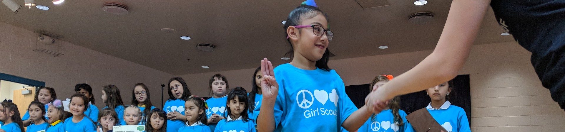  girl scout shakes staff hand at investiture ceremony 