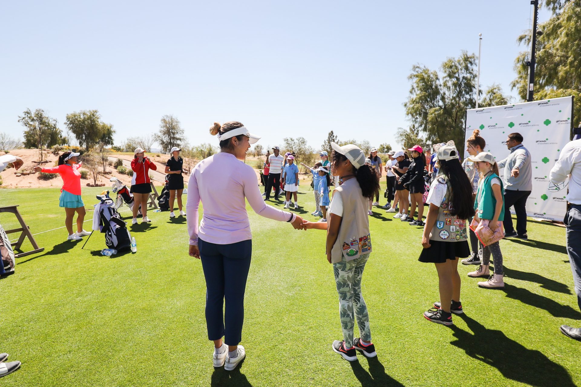 girl scout and pro golfer shaking hands