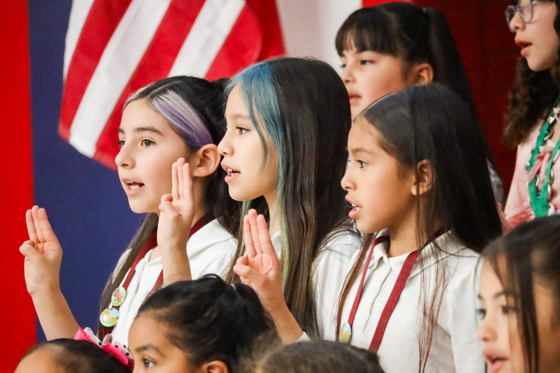 staff supported girl scouts doing the girl scout hand sign while reciting the promise and law
