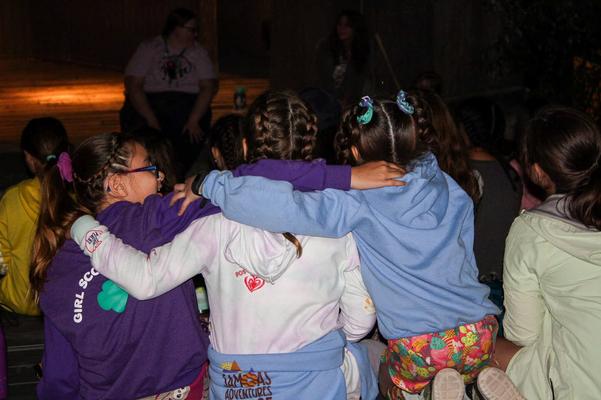 girl scouts bonding with arms around one another