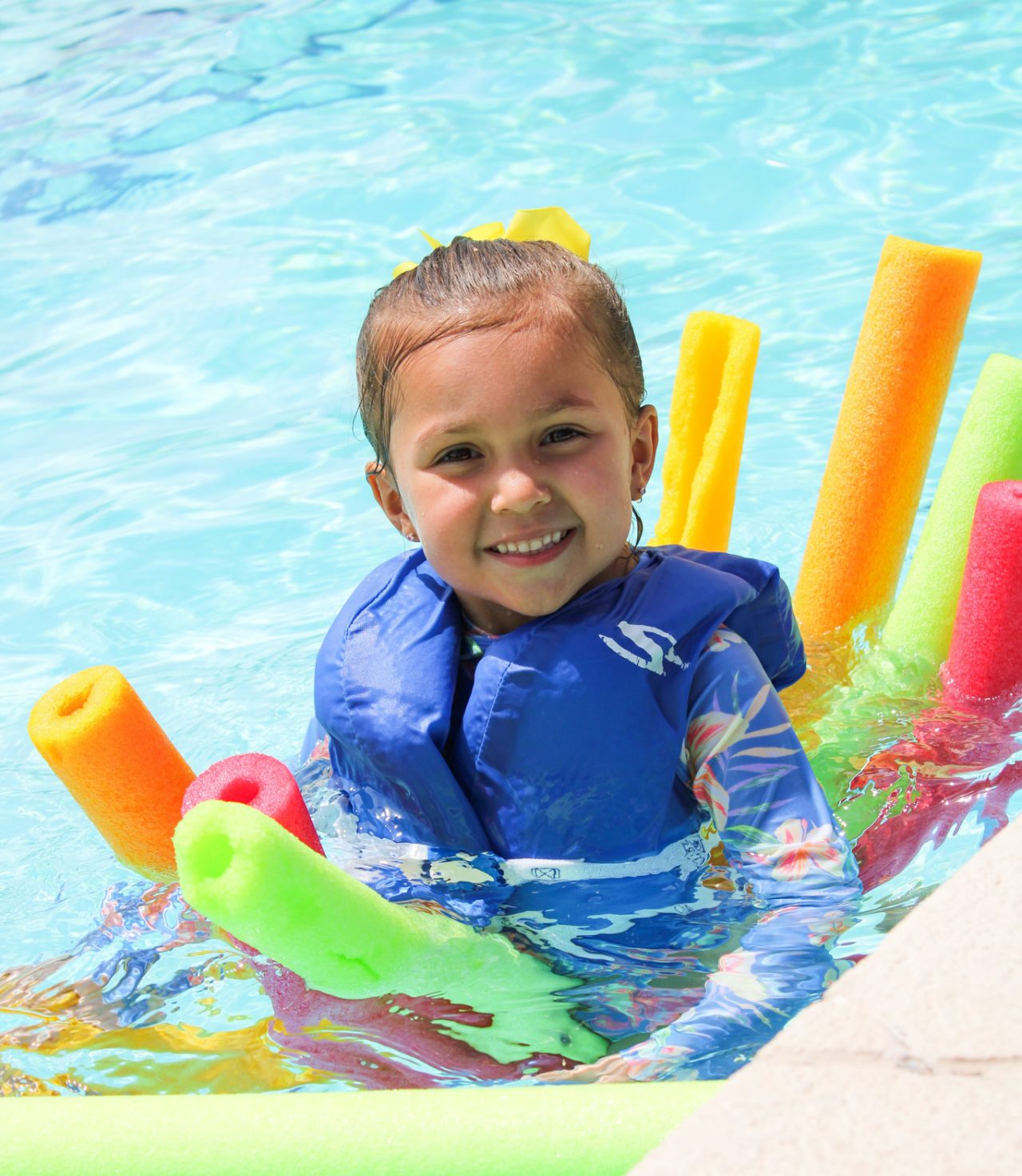 daisy girl scout with many colorful silly goofy pool noodles in the hacienda pool
