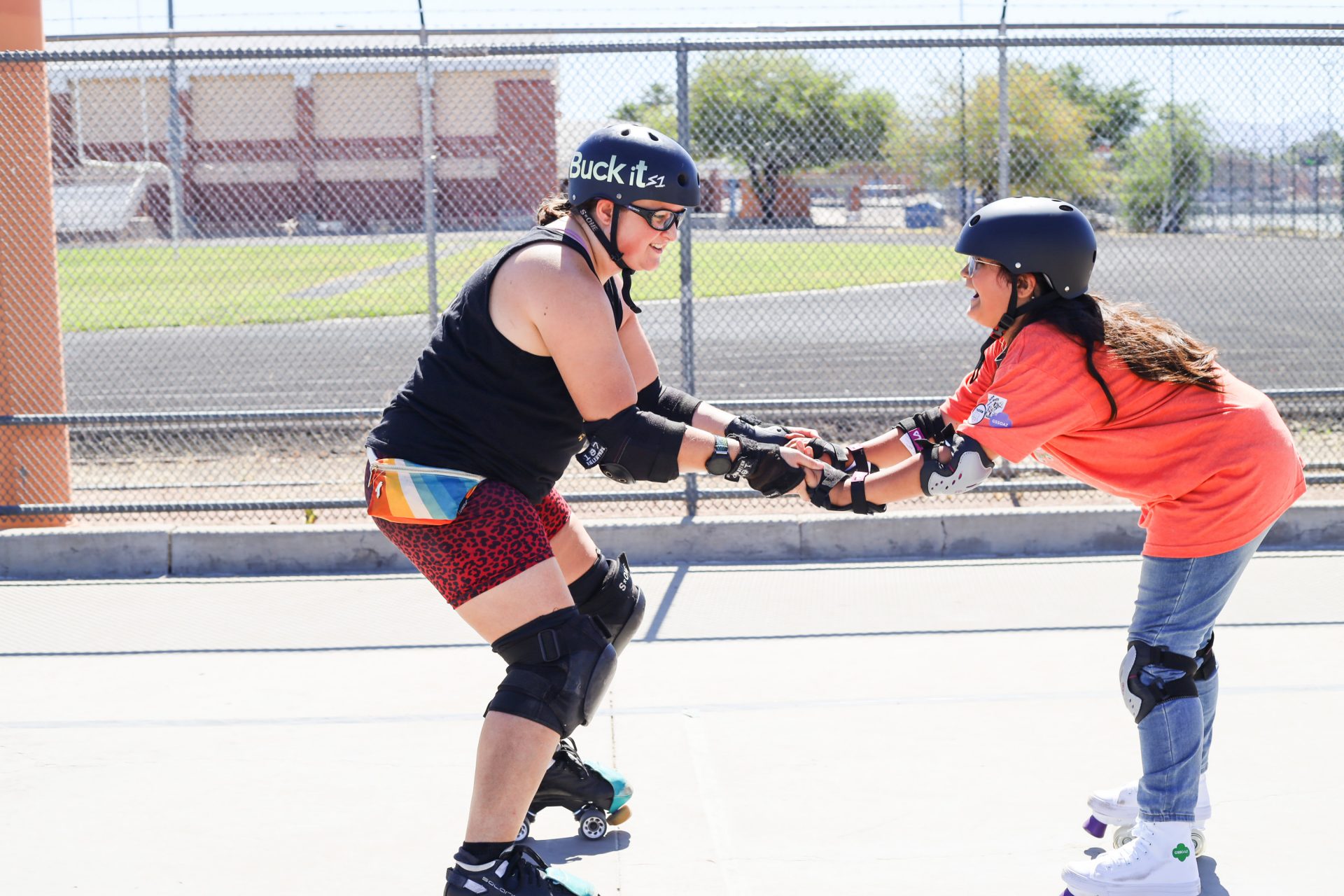 community partner assisting girl scout with roller blading