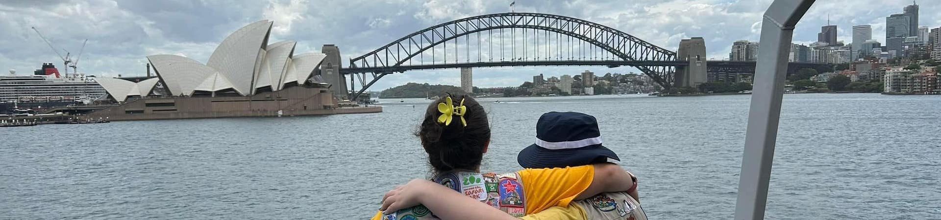  girl scouts with arms around one another looking at sydney opera house as a result of their cookie reward 