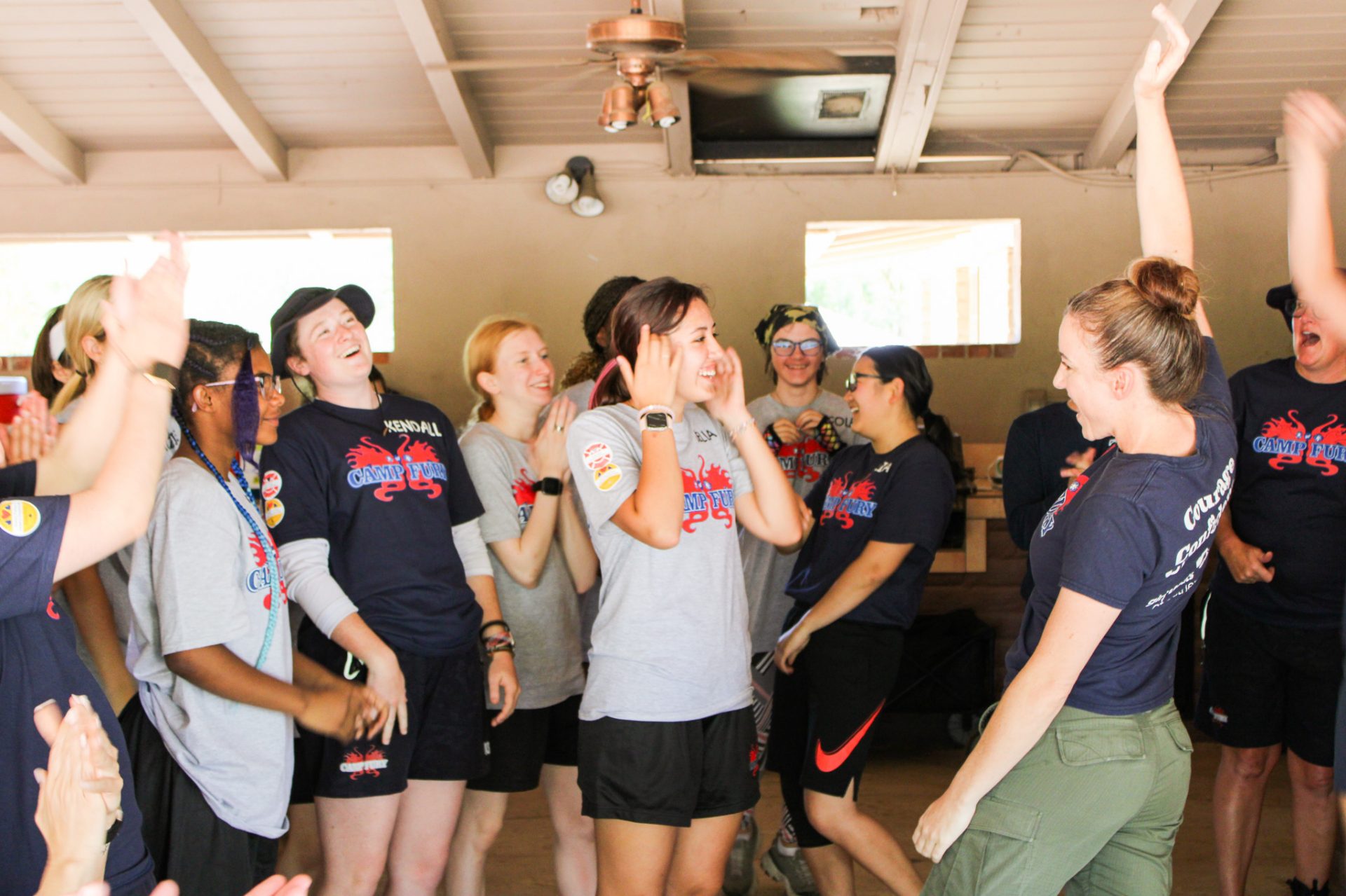 girl scouts cheering after playing rock, paper, scissors against camp fury volunteers 