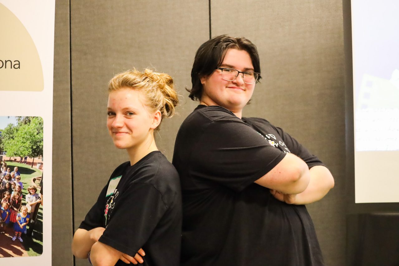 two gs adventure participants standing back to back and smiling