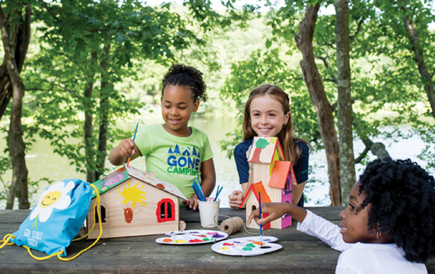 Three girls building birdhouses