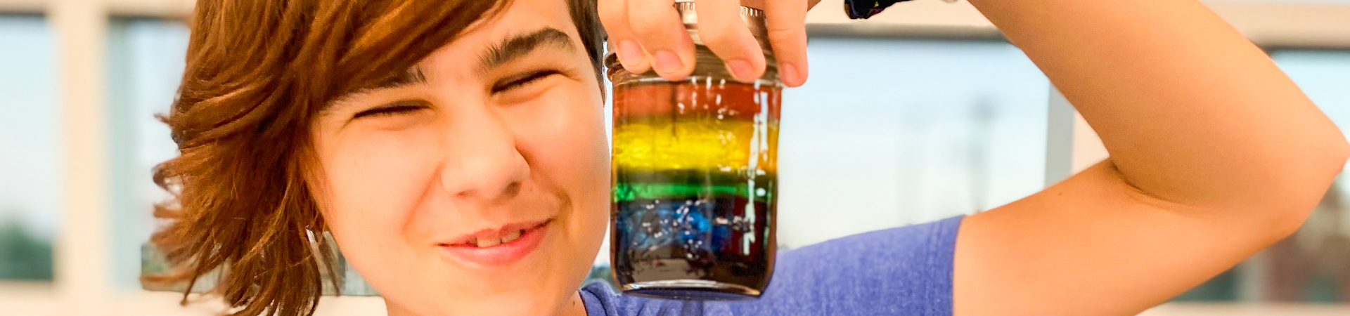  girl scout smiling and holding up sloppy science jar 