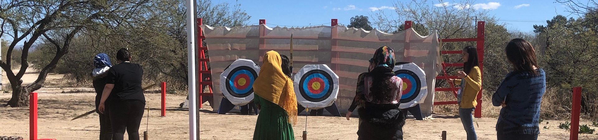  refugees participating in archery program with girl scout staff 