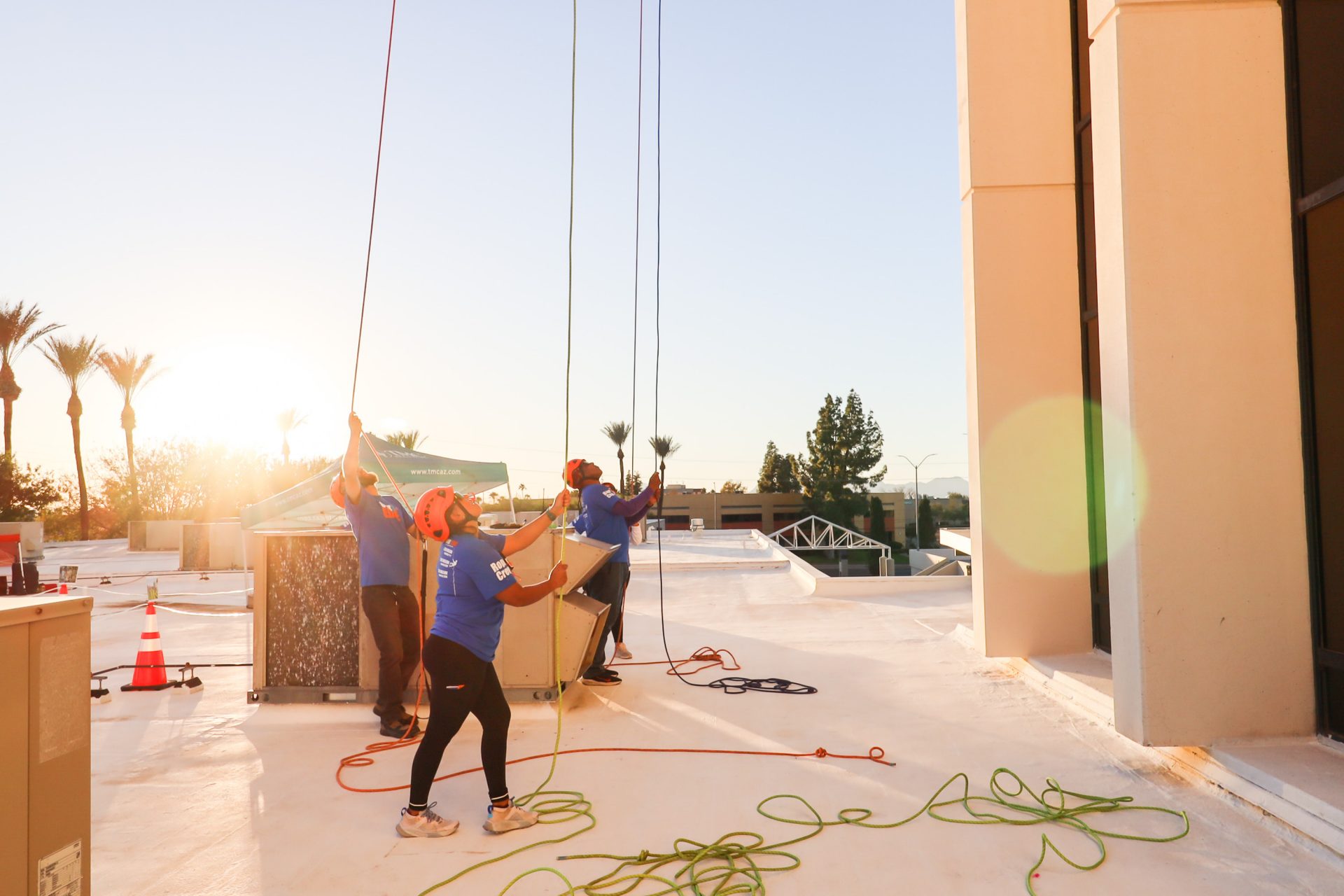 rope volunteers helping over the edge participants